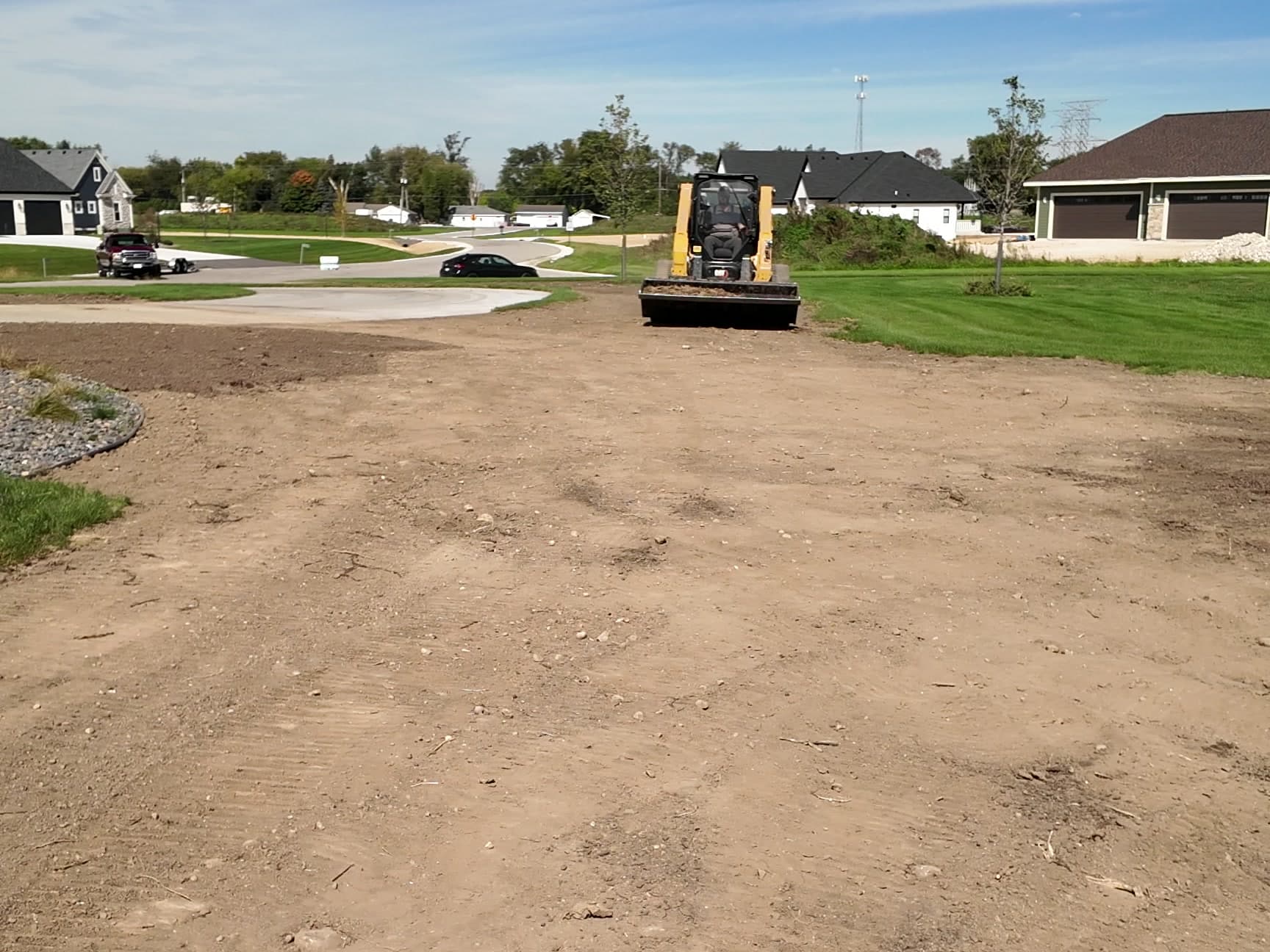 Skid steer regrading a new build yard in Hartland before hydroseed